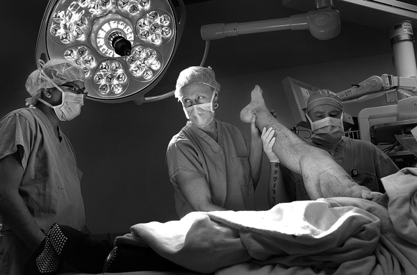 Surgeon Erik Kubiak examines the right leg
