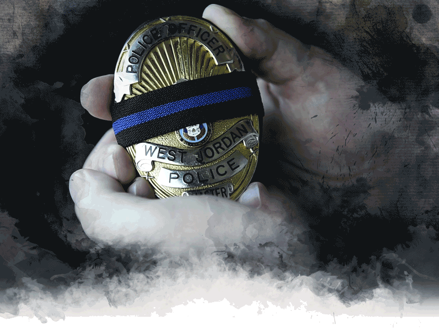 Detective Brent Jex runs his finger along the mourning band on his police badge