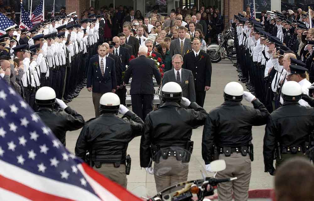Rows of officers salute the casket of Officer Ron Wood