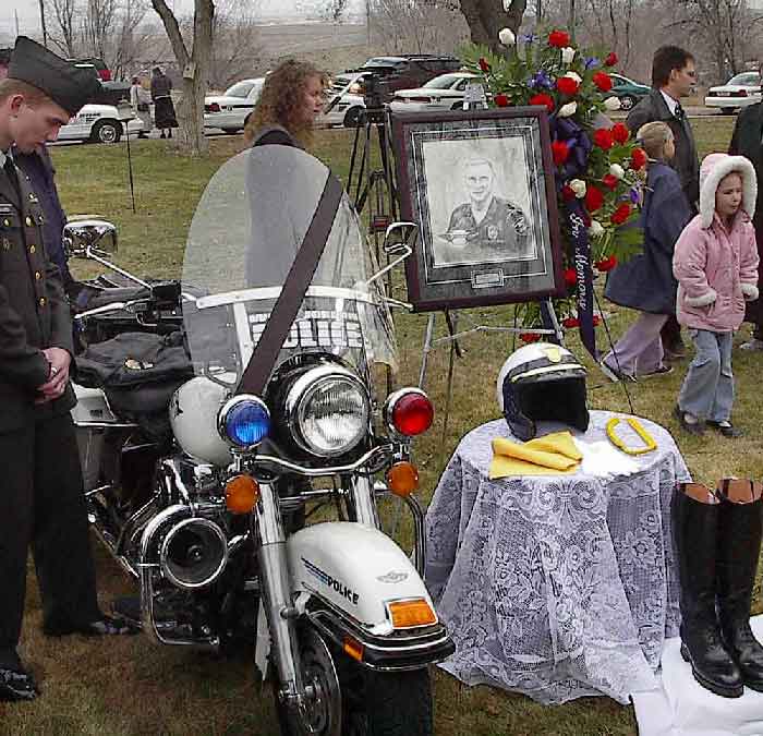 A memorial displays Ron Wood's motorcycle, helmet, boots and photo.