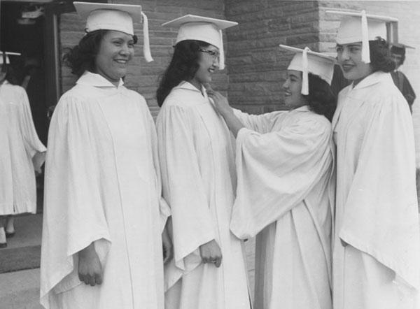 Four young women in graduation caps and gowns