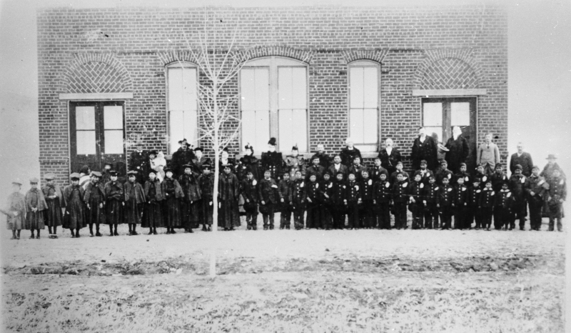 Historic photo of students in front of a brick building