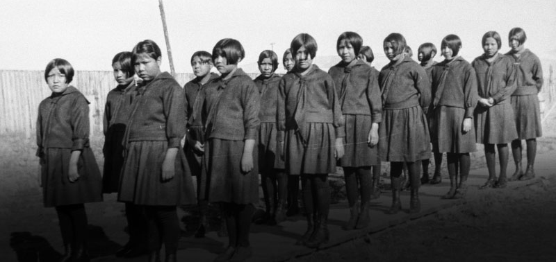 Young native girls stanging in rows in matching uniforms