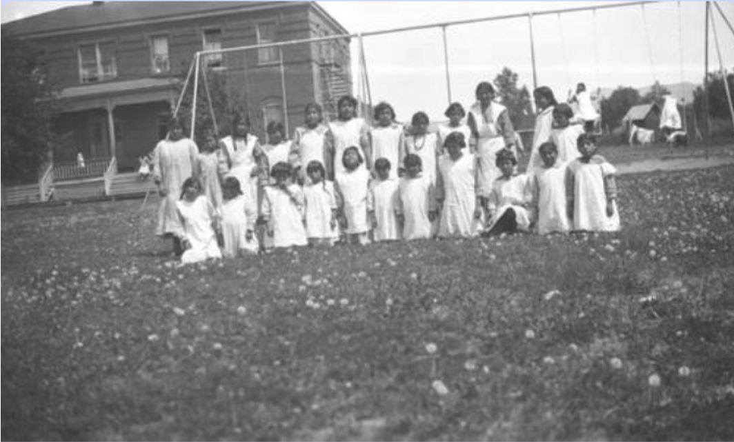 Histroic image of a group of girls in white dresses near a swing set